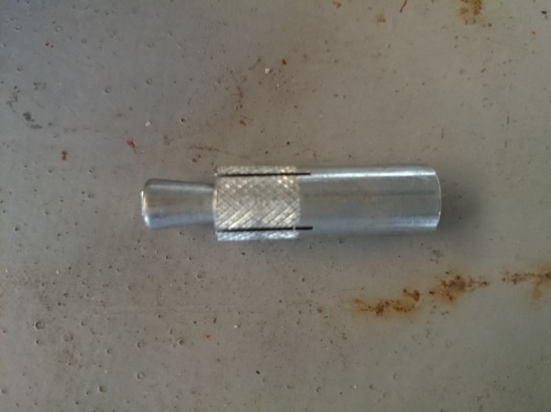 本体打ち込み式のアンカー。右側を打ち込むことで、左側の部品がアンカー内に入り込み、切れ目が入っている部分を広げる。