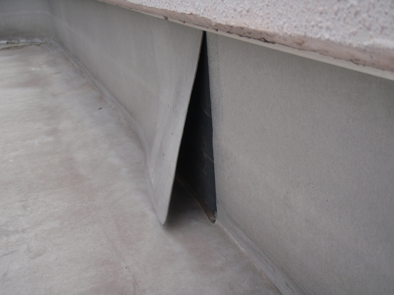 ゴムシート防水の立上り部が剥離した様子。
