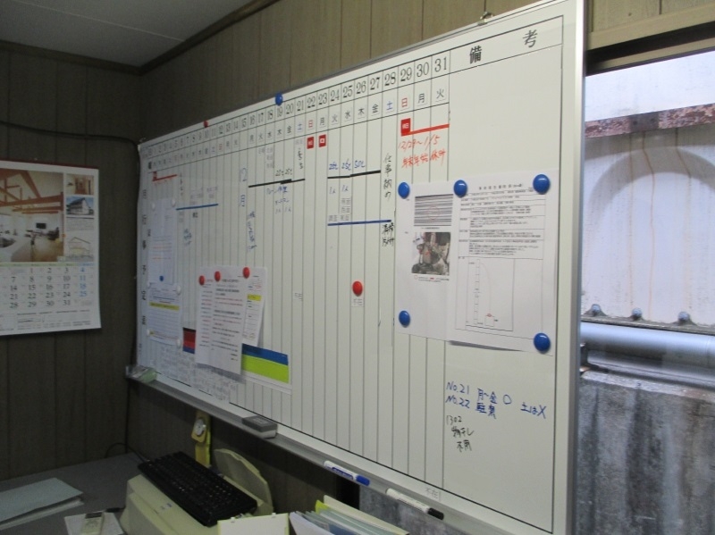 仮設事務所内の工程表。繁忙期は白い箇所が少なくなる。