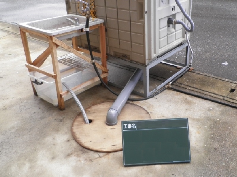 仮設トイレと手洗い。汚水桝や近隣の目などの都合で設置場所を決定する。