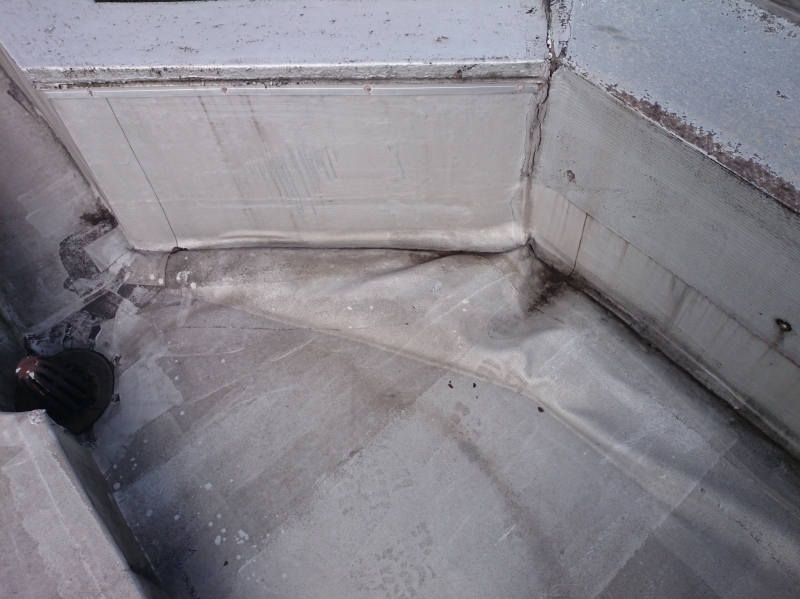 ゴムシート防水の立上り付近。上部は加工した金属笠木が設置されているが、隙間が多く、シーリング材に頼っている納まりになっているので雨水が入りやすい。