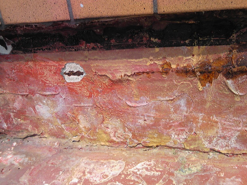 既存防水シートを撤去すると出てきた、被りが少ない鉄筋コンクリートの爆裂・露筋。それ以前に下地がボコボコしている。