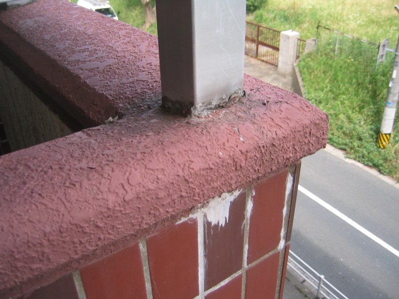 バルコニーの腰壁上に設置されているアルミ手摺の足元。下部にエフロレッセンスが見られる。