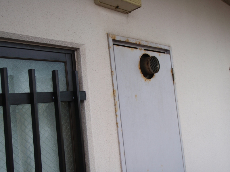 共用廊下のP.S（パイプシャフト）扉。発錆とチョーキングが進んでいる。曲げ・切断などの加工部が弱くなっている。