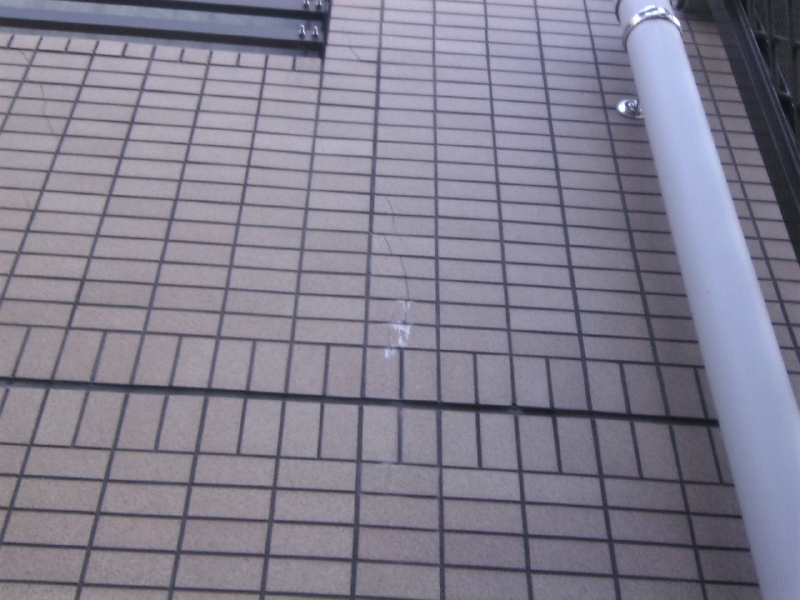 開口部（入り口や窓の様な、サッシや枠が入っている箇所）の四方は、周りから応力を受けるので、下地コンクリートはひび割れを起こし易い。　写真は、 （おそらく）タイルのひび割れから入った雨水が、コンクリートの成分である石灰質を運びだしている「エフロレッセンス（白華現象）」。コンクリートが雨水に侵され、劣化が始まっていることを示す。